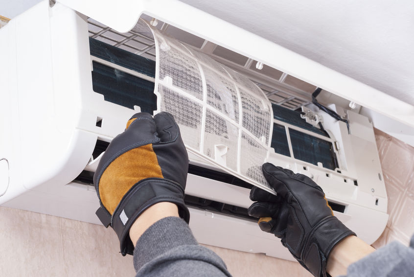 Specialist cleans and repairs the wall air conditioner